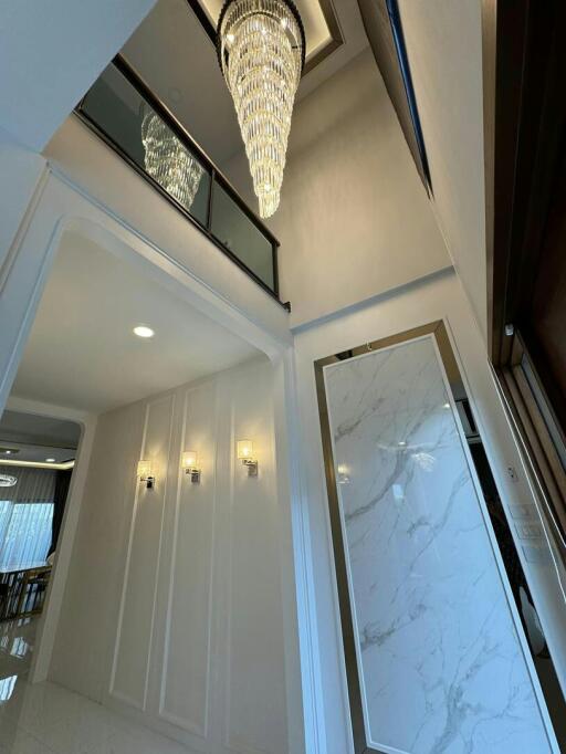 Elegant hallway interior with chandelier and marble wall