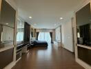 Spacious master bedroom with hardwood floors and modern furniture