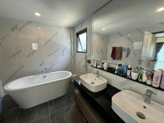 Modern bathroom with large bathtub and dual vanities