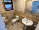 Compact bathroom with essential fixtures and tiled walls