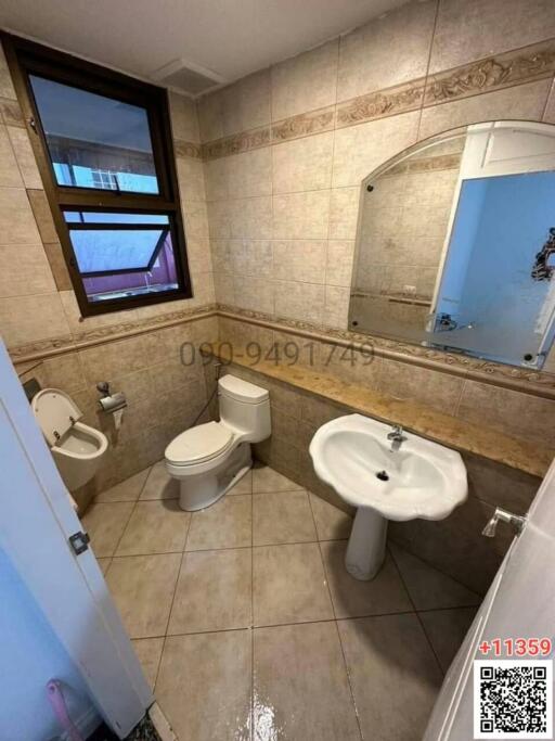 Compact bathroom with essential fixtures and tiled walls