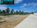 Empty residential lot ready for construction with a clear sky and surrounding palm trees