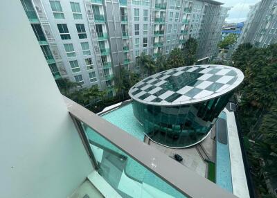 Apartment complex with balcony view showcasing the swimming pool and surrounding buildings