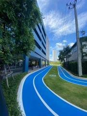 Modern residential building with outdoor running track and lush greenery