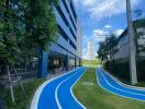 Modern residential building with outdoor running track and lush greenery