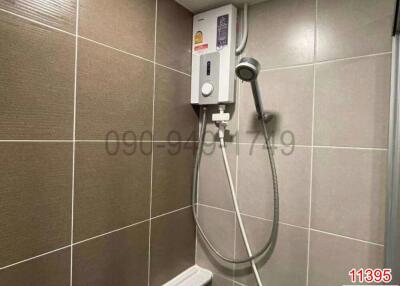 Modern bathroom with wall-mounted shower and tiled walls