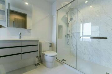 Modern bathroom with marble walls and glass shower