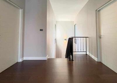 Spacious and Well-Lit Hallway with Hardwood Floors