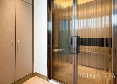 Modern hallway interior with built-in closets and frosted glass doors