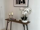 Elegant console table with decorative items and artwork in a modern living space