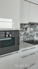 Modern kitchen with marble backsplash and built-in appliances