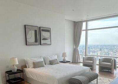 Spacious bedroom with large windows and a city view