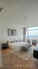 Spacious bedroom with large windows and a city view