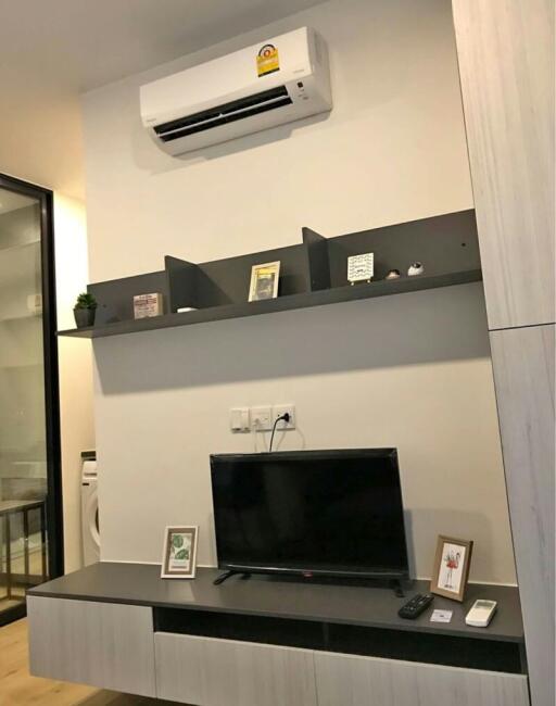 Modern living room with wall-mounted television and air conditioner