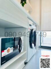 Compact laundry room with modern washing machine next to a bright window