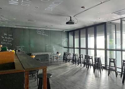Modern lounge with blackboard wall and bar seating by large windows