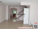 Spacious hallway with staircase and glossy tiled flooring in a house