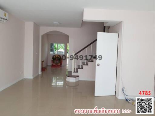 Spacious hallway with staircase and glossy tiled flooring in a house