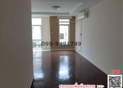 Spacious empty living room with glossy hardwood flooring and ample natural light