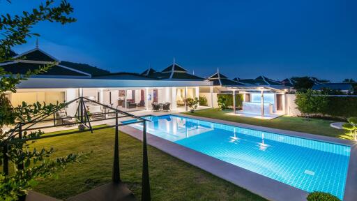 Luxurious home exterior with a swimming pool at twilight