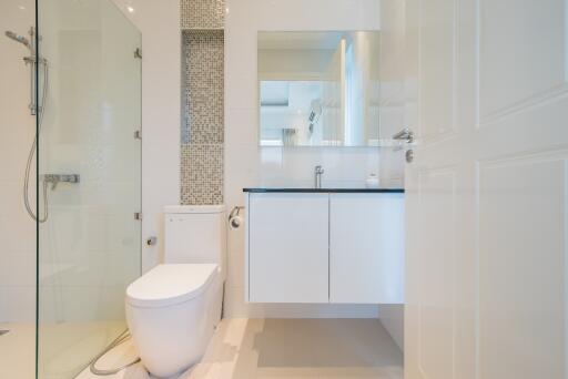 Modern bathroom with walk-in shower, toilet, and vanity area