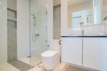 Modern bathroom with glass shower and white cabinetry