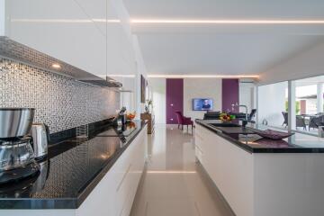 Modern kitchen with open plan layout leading to a living area