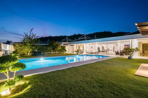 Elegant house with swimming pool and landscaped garden during twilight