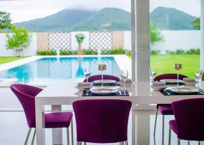 Elegant dining area with a view of the pool and mountains