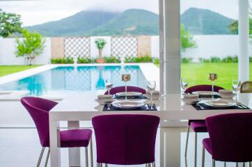 Elegant dining area with a view of the pool and mountains