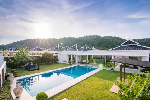 Spacious backyard with a swimming pool and beautiful landscape during sunset