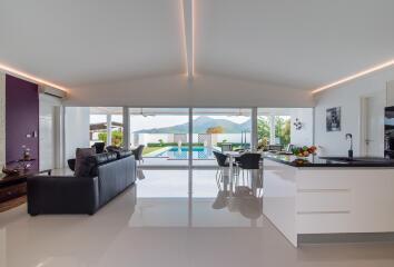 Modern open-plan living room and kitchen with natural light and scenic view
