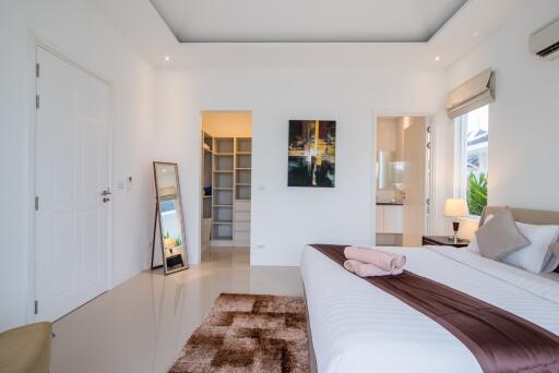 Modern and cozy bedroom with a comfortable bed, artwork, and ample lighting