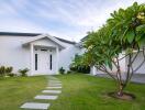 Modern single-story house front with landscaped garden and pathway