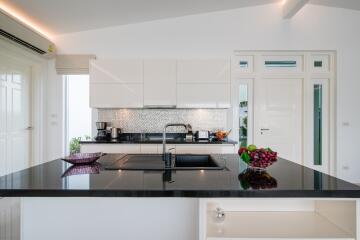 Modern kitchen with black countertops and white cabinetry