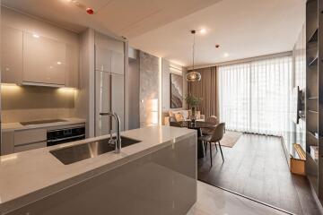 Modern kitchen with integrated appliances and adjacent dining space with natural light