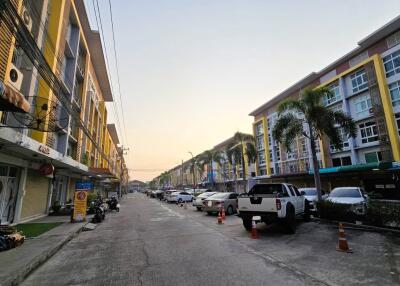 Townhouse residential street view at dusk with parked cars