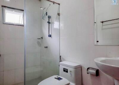 Compact white bathroom with a walk-in shower, toilet, and washbasin