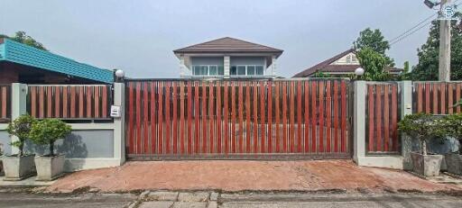 Front gate of a residential house with a clear view of the house facade.