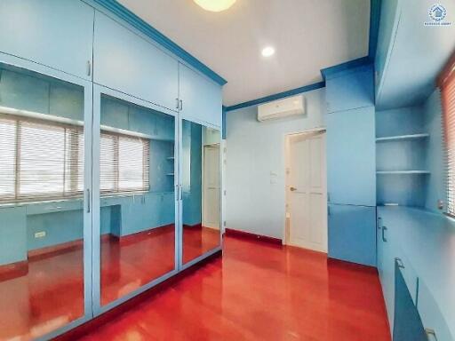 Spacious bedroom with large mirrored closet and red floor