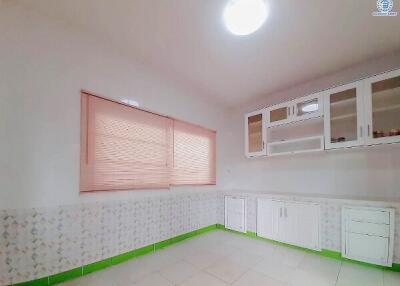 Spacious kitchen with white cabinetry and large window