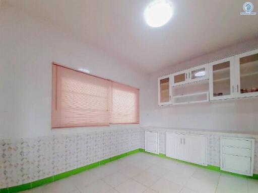 Spacious kitchen with white cabinetry and large window