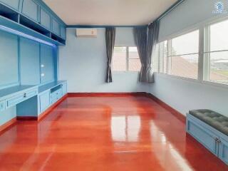 Spacious bedroom with built-in shelving and glossy red flooring