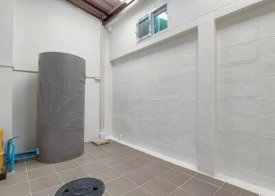 Spacious utility room with water heater and tiled flooring