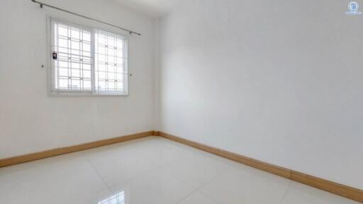 Bright empty bedroom with large window and tiled flooring