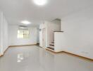 Bright and spacious interior of a modern building, showing a room with glossy tiled floor and clean white walls