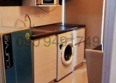 Compact kitchen with modern appliances and washing machine
