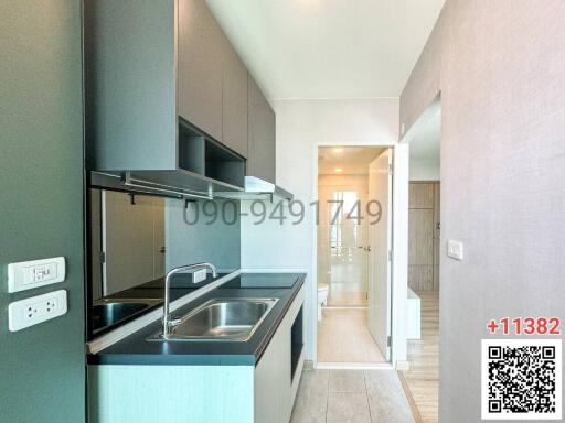 Modern kitchen leading to a corridor with neutral colors and ample daylight