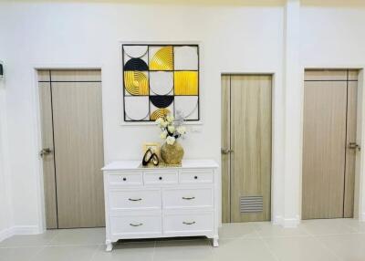 Elegant hallway interior with decorative wall art and white drawer cabinet
