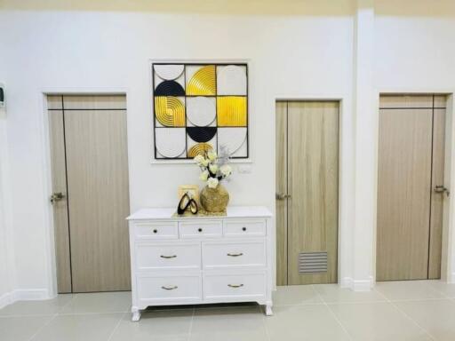 Elegant hallway interior with decorative wall art and white drawer cabinet
